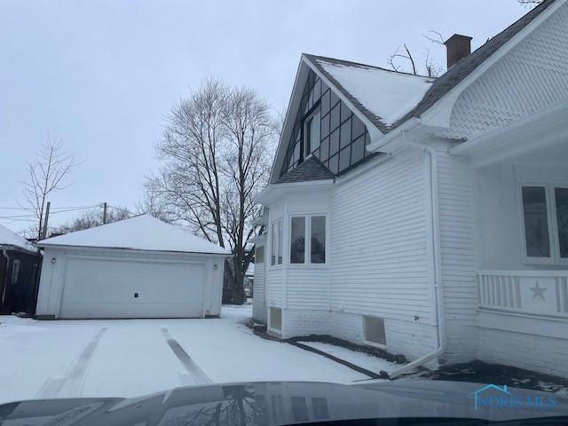 view of snowy exterior featuring a garage