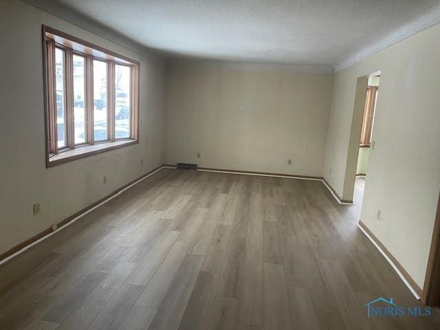 unfurnished room with a textured ceiling and hardwood / wood-style floors