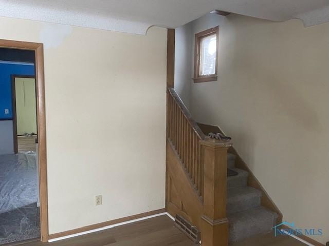 staircase with hardwood / wood-style flooring