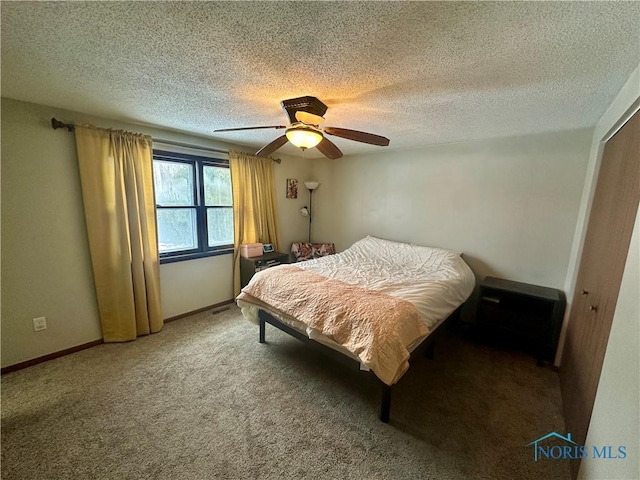 bedroom with ceiling fan, carpet floors, a textured ceiling, and a closet