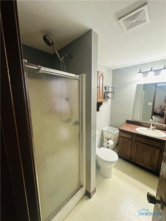 bathroom featuring vanity, toilet, and walk in shower