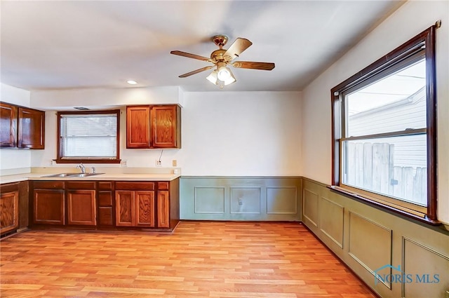 kitchen with sink, ceiling fan, light hardwood / wood-style flooring, and plenty of natural light