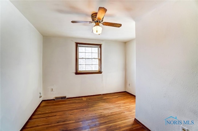 spare room featuring ceiling fan and dark wood-type flooring