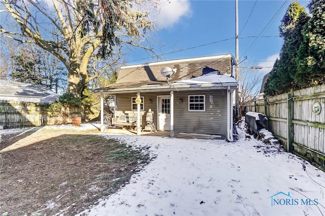 view of snow covered rear of property