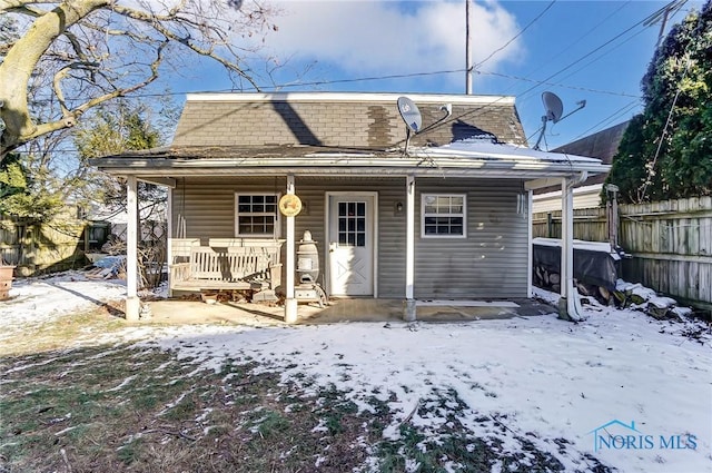 snow covered property featuring covered porch