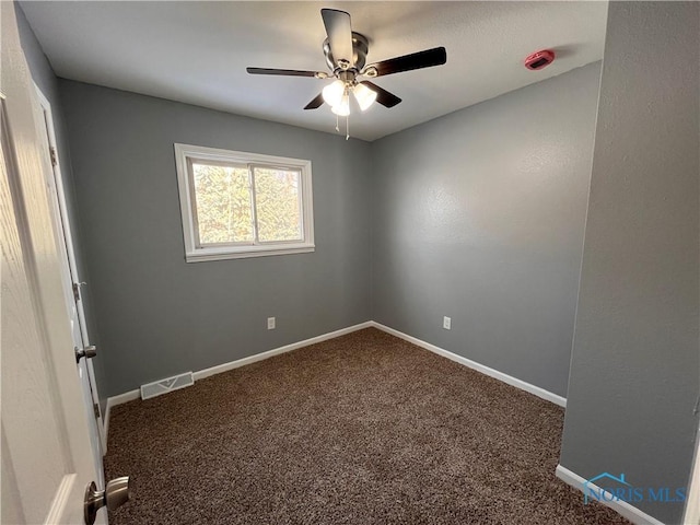 carpeted spare room featuring ceiling fan