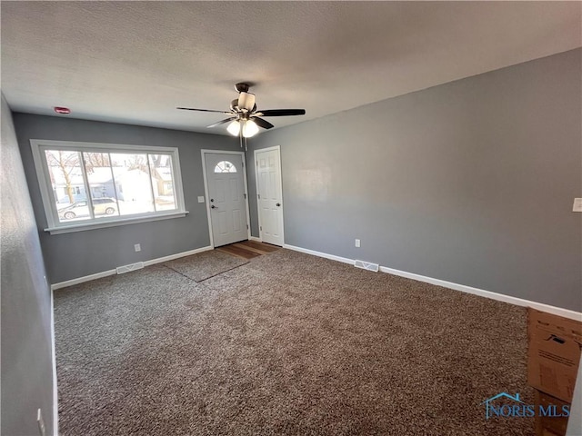 carpeted entrance foyer featuring a textured ceiling and ceiling fan