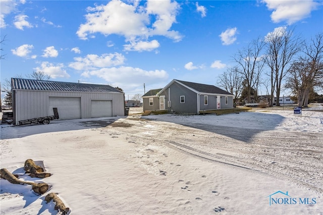 exterior space with a garage and an outbuilding