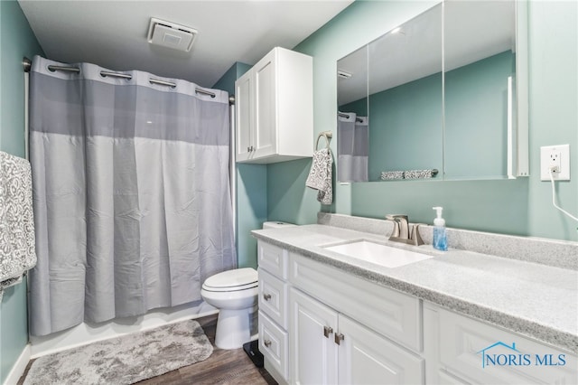 bathroom with toilet, hardwood / wood-style flooring, and vanity