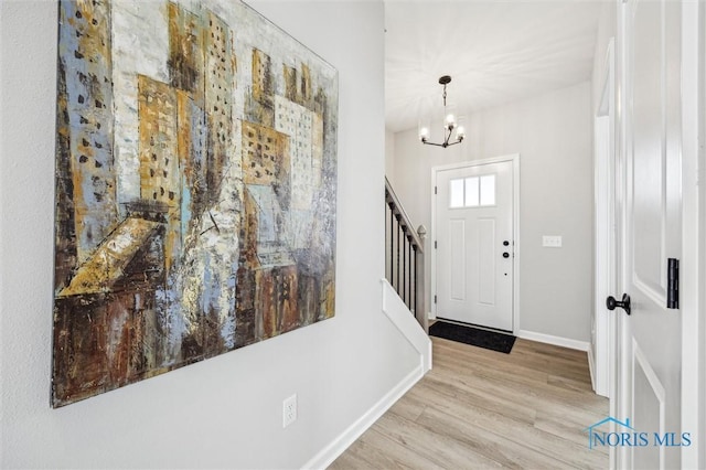 foyer entrance with light hardwood / wood-style flooring and a notable chandelier