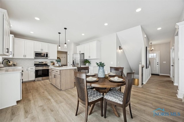 kitchen with white cabinets, pendant lighting, appliances with stainless steel finishes, and a center island