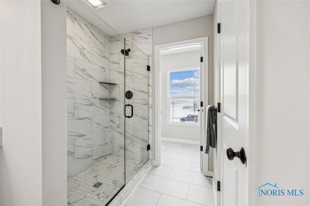 bathroom featuring a shower with shower door and tile patterned floors