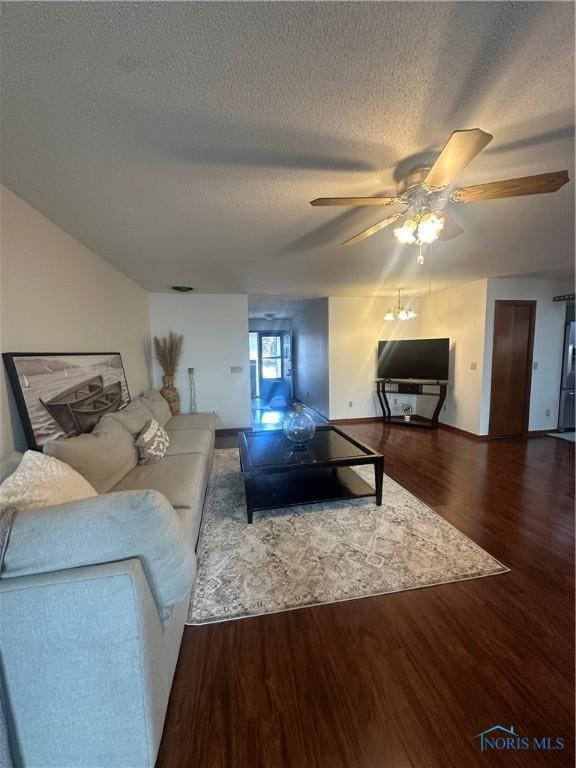 living room featuring a textured ceiling, ceiling fan, and dark hardwood / wood-style floors