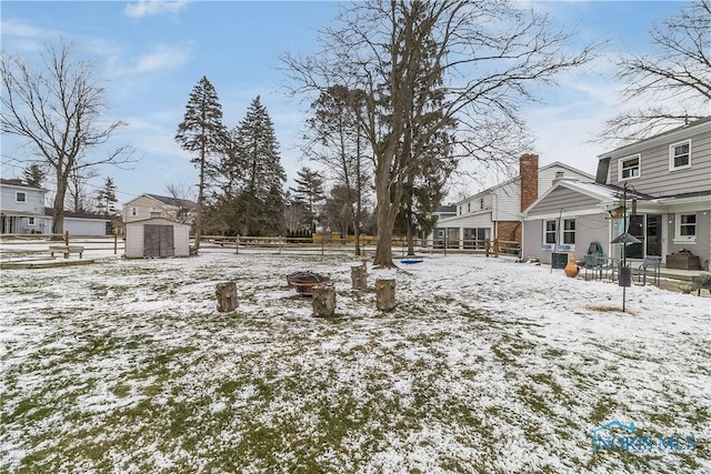 yard covered in snow featuring a storage shed