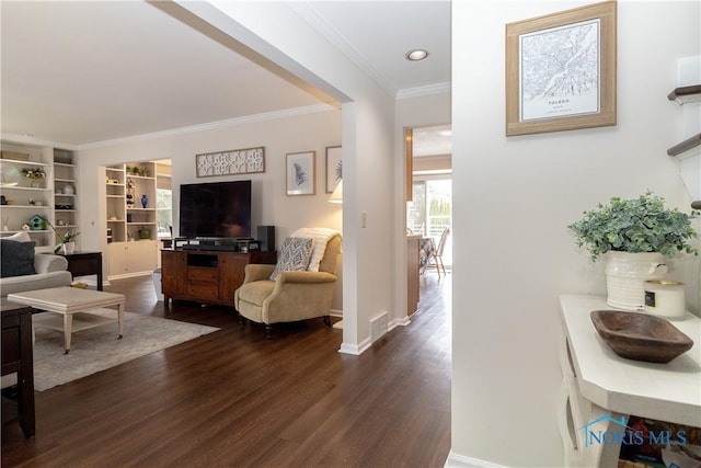 living room featuring built in features, dark hardwood / wood-style flooring, and ornamental molding