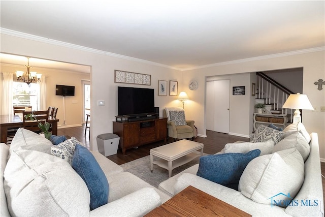 living room featuring dark hardwood / wood-style floors, crown molding, and a notable chandelier