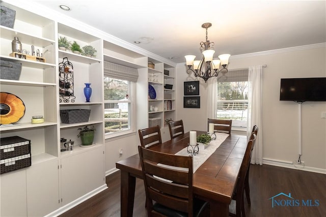 dining room with an inviting chandelier, crown molding, and dark hardwood / wood-style floors