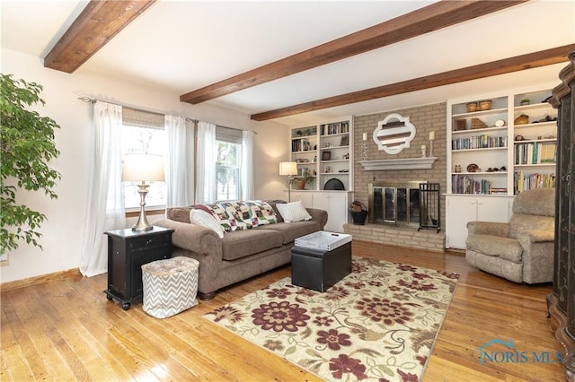 living room with a brick fireplace, beam ceiling, and light hardwood / wood-style floors