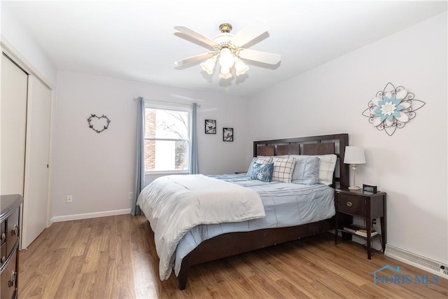 bedroom with ceiling fan, a closet, and light hardwood / wood-style floors