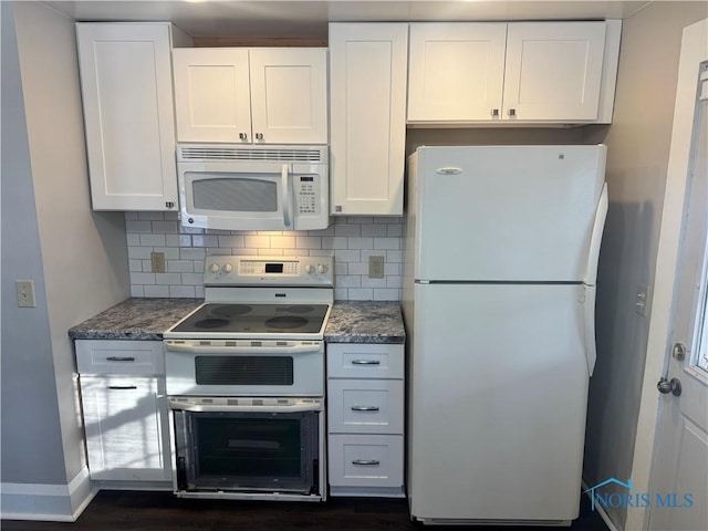 kitchen featuring tasteful backsplash, dark stone counters, white appliances, and white cabinetry