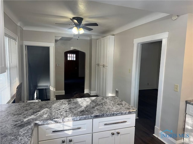 kitchen with ceiling fan, dark wood-type flooring, white cabinets, and stone counters