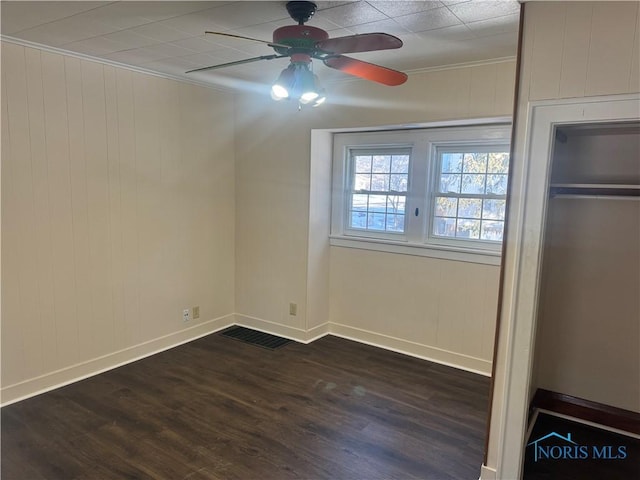 unfurnished bedroom featuring ceiling fan, dark hardwood / wood-style floors, a closet, and ornamental molding