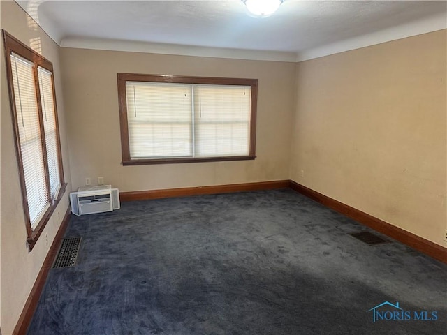 unfurnished room featuring dark carpet and a wall mounted air conditioner