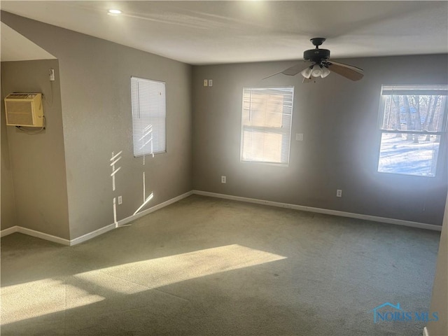 carpeted empty room with ceiling fan and a wall unit AC