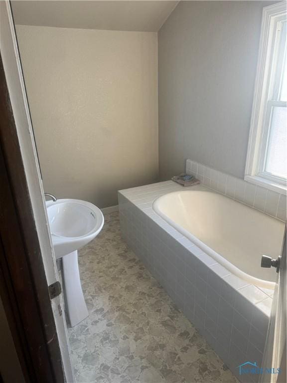 bathroom featuring a relaxing tiled tub