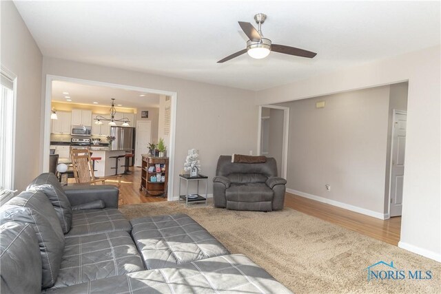 carpeted living room featuring ceiling fan