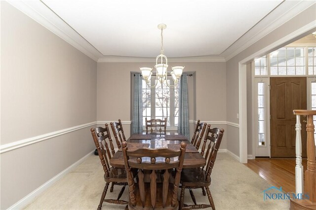 dining space featuring a healthy amount of sunlight, an inviting chandelier, and light colored carpet