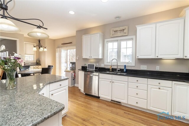 kitchen with stainless steel dishwasher, white cabinets, hanging light fixtures, and sink