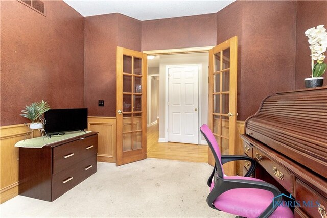 carpeted home office featuring french doors