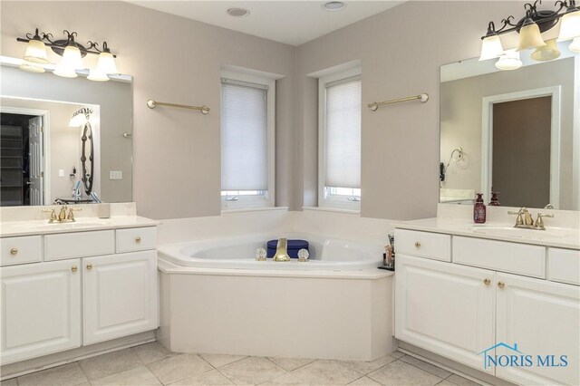 bathroom featuring tile patterned flooring, vanity, and a tub