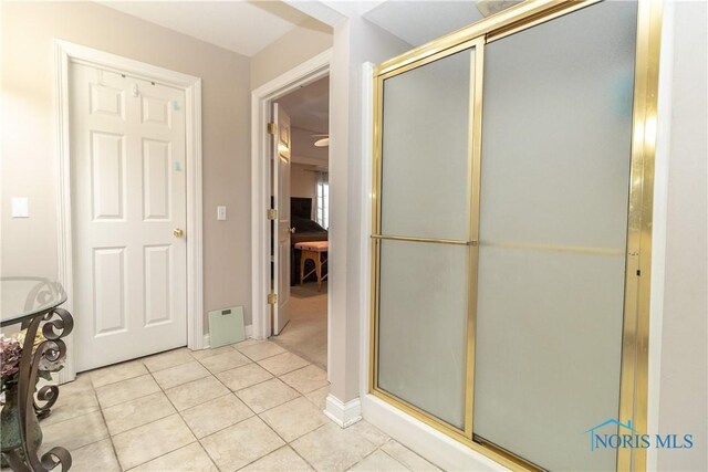 bathroom featuring an enclosed shower and tile patterned floors