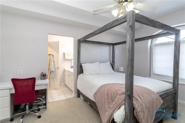 bedroom with ceiling fan, ensuite bathroom, and light carpet