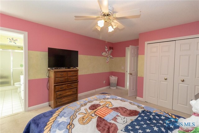 carpeted bedroom featuring ceiling fan, a closet, and ensuite bath