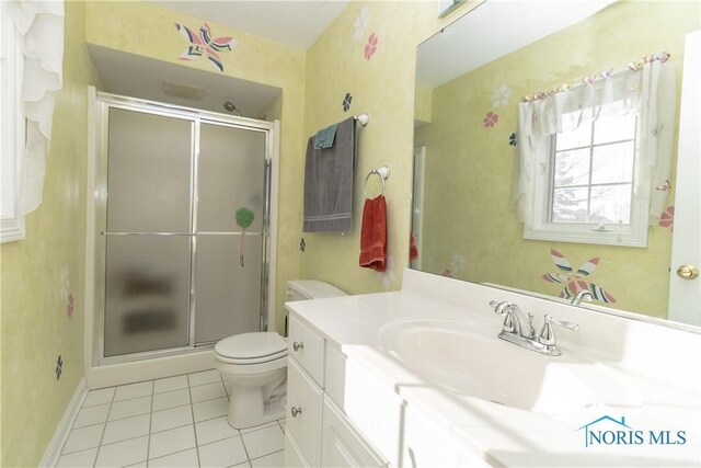 bathroom featuring vanity, toilet, tile patterned flooring, and a shower with door