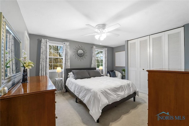 carpeted bedroom with ceiling fan and a closet