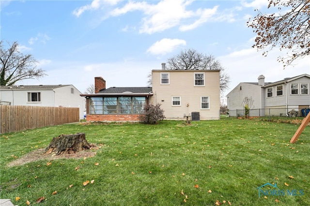 back of property with cooling unit and a lawn