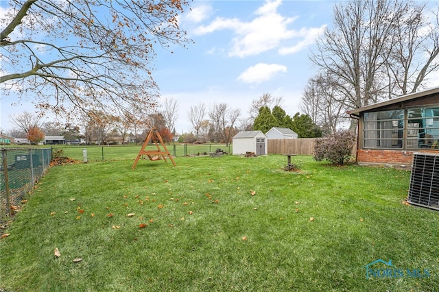 view of yard featuring a shed and central AC unit