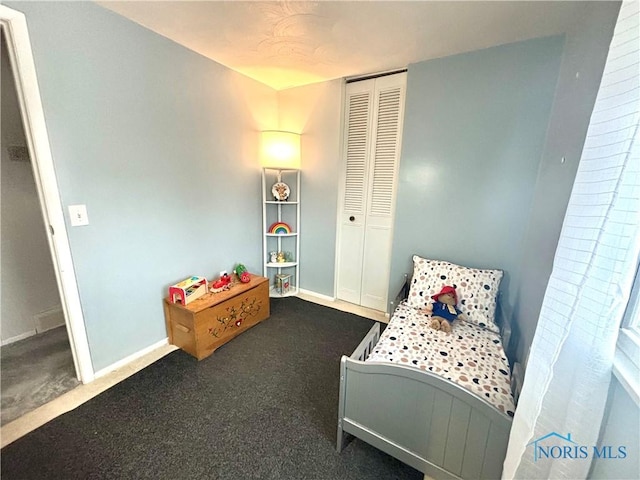 bedroom with a closet and dark colored carpet