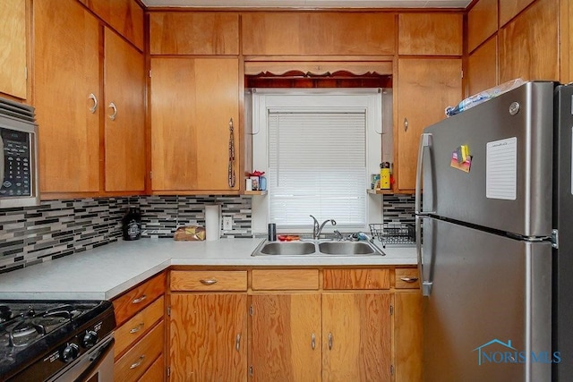 kitchen featuring backsplash, appliances with stainless steel finishes, and sink