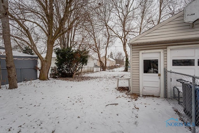 yard covered in snow featuring a garage