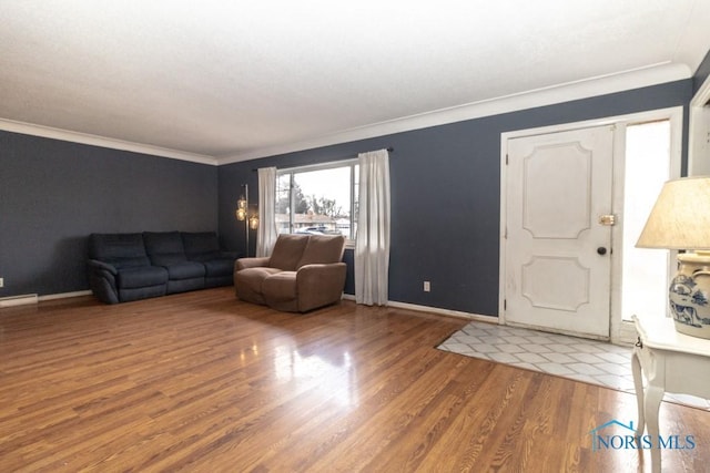 entryway with ornamental molding and hardwood / wood-style floors