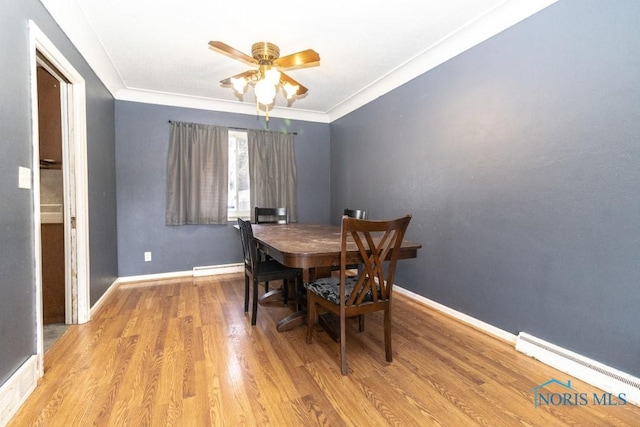 dining room with ceiling fan, baseboard heating, ornamental molding, and light hardwood / wood-style flooring