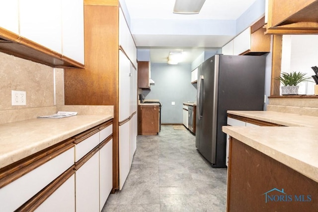 kitchen featuring decorative backsplash, white cabinetry, and stainless steel refrigerator