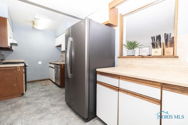 kitchen with white cabinets, appliances with stainless steel finishes, sink, and range hood