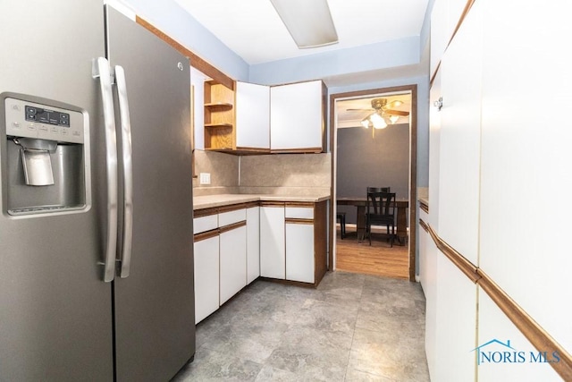 kitchen featuring white cabinetry, backsplash, and stainless steel fridge