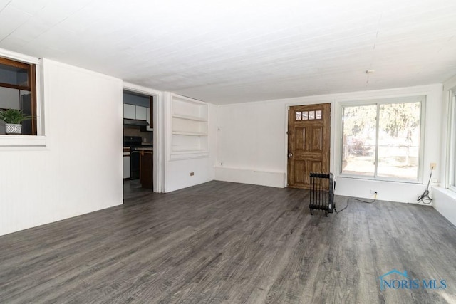 unfurnished living room with dark wood-type flooring and built in features